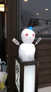 Snowman on top of a shop signage